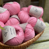 A basket filled with balls of pink yarn