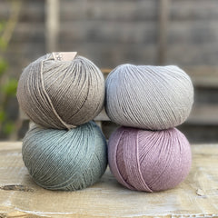 Four balls of Milburn. On the top row is a grey ball and a pale blue ball. On the bottom row is a blue-green ball and pale purple ball