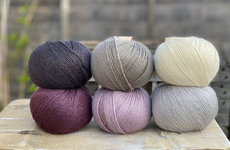 Six balls of Milburn 4ply in shades of grey, cream and purple