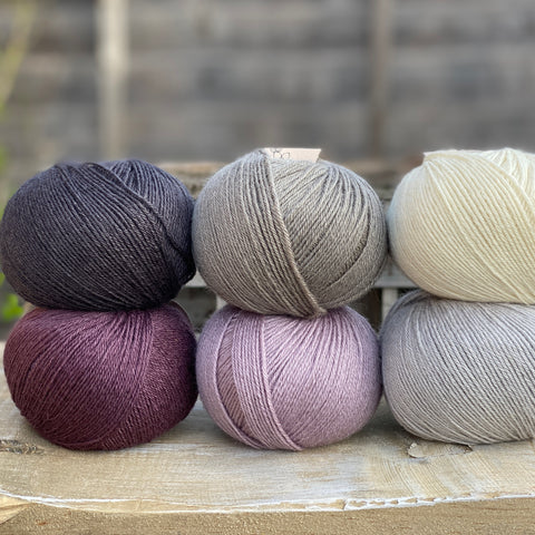 Six balls of Milburn 4ply in shades of grey, cream and purple
