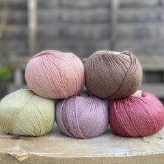 Five balls of Milburn in shades of pink, purple, green and brown