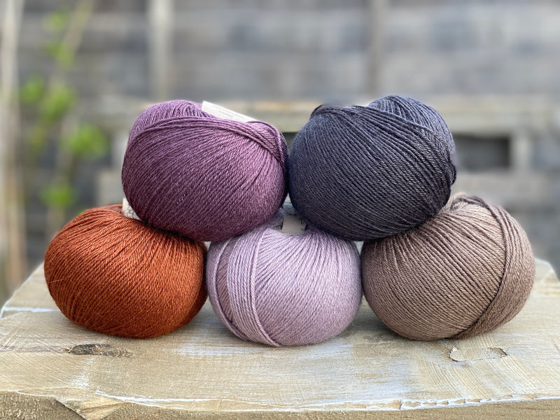 Milburn 4ply in shades of purple, black, brown and rust