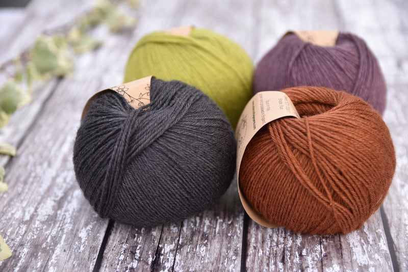 Four balls of Milburn in shades of green, purple, grey and brown