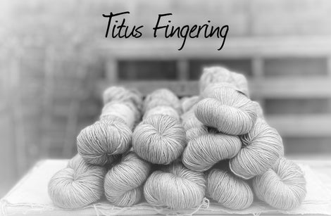 Black and white image of skeins of yarn with "Titus Fingering" overlaid in black text